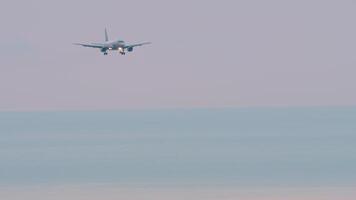 lange Schuss von ein Jet Passagier Flugzeug Annäherung Landung im ein düster Himmel. Sonnenuntergang oder Dämmerung, Flugzeug im das Himmel. Verkehrsflugzeug Abstieg, Ankunft. Reise Konzept video