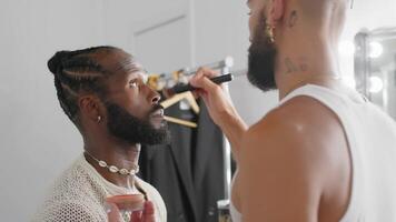 a man with a beard is getting his makeup done video