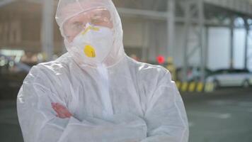 a man in a white protective suit is standing looking at the camera video