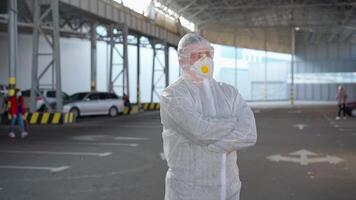 a man in a white protective suit is standing looking at the camera video