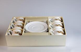 Set of antique porcelain coffee cups with a bow on a white background. photo
