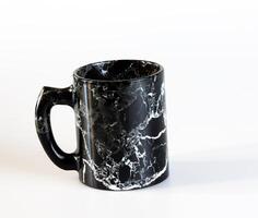 Drink cup made of natural black obsidian. Isolated on a white background. photo