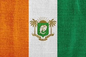 Flag and coat of arms of Republic of Cote d'Ivoire on a textured background. Concept collage. photo