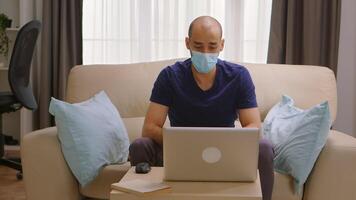 Man with protection mask on a business video call during covid-19.