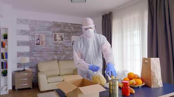 social trabajador embalaje comida durante codicioso aislamiento vistiendo materiales peligrosos traje. video