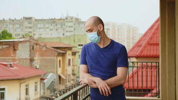 ansioso homem com mascarar em terraço durante coronavírus pandemia. video
