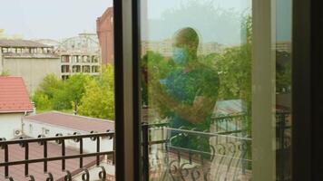 Reflexion of man on balcony clapping for doctors and nurses on fight against coronavirus. video