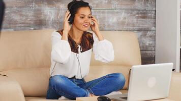 Woman using headphones communicate with hear teamwork during a video call while working from home.