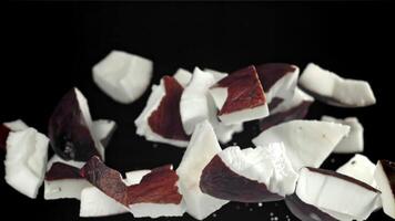 Pieces of coconut fly up and fall down. Filmed on a high-speed camera at 1000 fps. High quality FullHD footage video