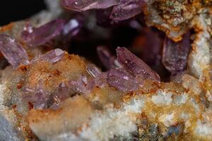 macro mineral amethyst stone in rock on a black background photo