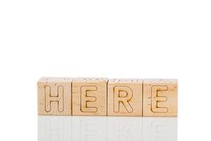 Wooden cubes with letters here on a white background photo