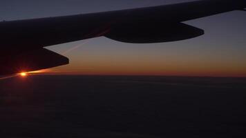 View from the airplane window of the wing, clouds and a beautiful sunset. video