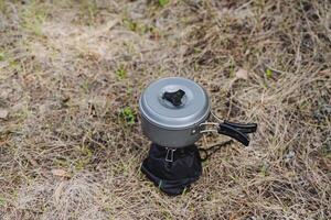 Tourist pot stands on a gas burner, aluminum dishes for cooking on a hike, tourist food to cook in the boiler, light equipment photo