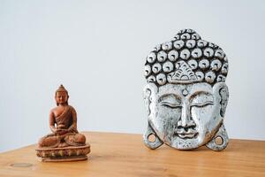 The image of the Buddha is on the table. The buddha's head is silver in color. The statuette is small in Buddhism. photo