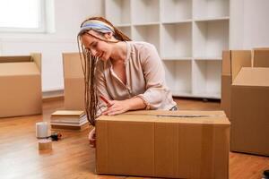 Modern ginger woman with braids moving into new home. photo