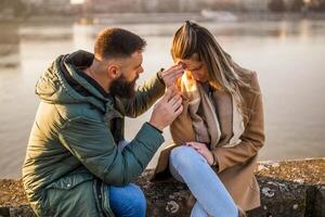 Couple having conflict and man is trying to comfort his sad and angry woman after arguing photo