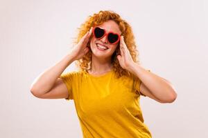 Image of happy ginger woman with red heart shaped sunglasses photo