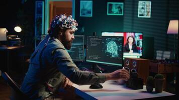 ingenjör med eeg headsetet införing patron in i pc till använda sig av hög tech programvara tillåter för hjärna överföra in i virtuell värld. man sätta disk i dator till Start medvetande ladda upp, kamera b video