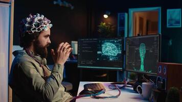 IT technician using EEG headset stupefied after mind upload virtual process is successful. Man astounded after achieving goal of transferring consciousness into computer cyberspace, camera B video