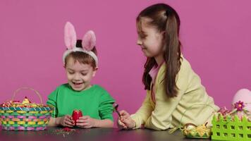 begeistert Kinder brechen ein Besondere Ostern Ei zu finden ein Überraschung innen, Gefühl neugierig Über ein festlich Dekoration Das transformiert im ein Pflanze. heiter wenig Kinder haben Spaß im Studio. Kamera a. video