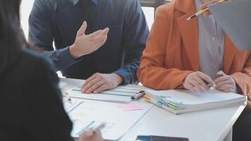Close-up asia business people meeting plan analysis statistics brainstorm and header of team hold tablet pointing graph chart and employee take note. Finance strategy statistics success concept. video
