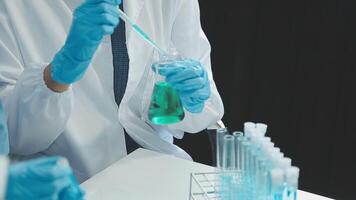 Doctor hand taking a blood sample tube from a rack with machines of analysis in the lab background, Technician holding blood tube test in the research laboratory. video