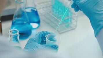 Doctor hand taking a blood sample tube from a rack with machines of analysis in the lab background, Technician holding blood tube test in the research laboratory. video