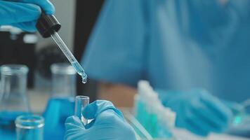 Doctor hand taking a blood sample tube from a rack with machines of analysis in the lab background, Technician holding blood tube test in the research laboratory. video