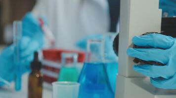 Doctor hand taking a blood sample tube from a rack with machines of analysis in the lab background, Technician holding blood tube test in the research laboratory. video