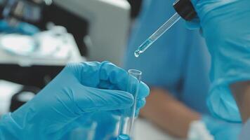 Doctor hand taking a blood sample tube from a rack with machines of analysis in the lab background, Technician holding blood tube test in the research laboratory. video