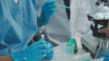 médico mano tomando un sangre muestra tubo desde un estante con máquinas de análisis en el laboratorio fondo, técnico participación sangre tubo prueba en el investigación laboratorio. video