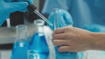 Doctor hand taking a blood sample tube from a rack with machines of analysis in the lab background, Technician holding blood tube test in the research laboratory. video