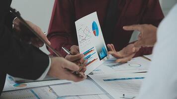 bedrijf team samenwerking bespreken werken analyseren met financieel gegevens en afzet groei verslag doen van diagram in team, presentatie en brainstorming naar strategie planning maken winst van bedrijf. video