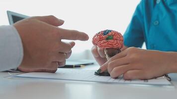 neurólogo mano señalando cerebro anatomía humano modelo y cerebro enfermedad lesión en blanco fondo.parte de humano cuerpo modelo con Organo sistema para salud y médico estudiante estudiar en universidad. video