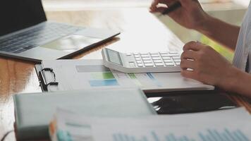 Asian Businesswoman Using laptop computer and working at office with calculator document on desk, doing planning analyzing the financial report, business plan investment, finance analysis concept. video