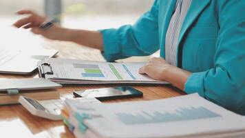 Asian Businesswoman Using laptop computer and working at office with calculator document on desk, doing planning analyzing the financial report, business plan investment, finance analysis concept. video