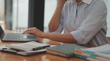 Asian Businesswoman Using laptop computer and working at office with calculator document on desk, doing planning analyzing the financial report, business plan investment, finance analysis concept. video