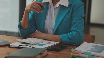 Asian Businesswoman Using laptop computer and working at office with calculator document on desk, doing planning analyzing the financial report, business plan investment, finance analysis concept. video