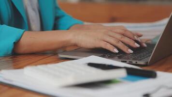 Asian Businesswoman Using laptop computer and working at office with calculator document on desk, doing planning analyzing the financial report, business plan investment, finance analysis concept. video