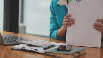 femme d'affaires asiatique utilisant un ordinateur portable et travaillant au bureau avec un document de calculatrice sur le bureau, faisant la planification en analysant le rapport financier, l'investissement dans le plan d'affaires, le concept d'analyse financière. video