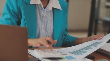 Asian Businesswoman Using laptop computer and working at office with calculator document on desk, doing planning analyzing the financial report, business plan investment, finance analysis concept. video