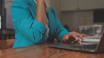 Asian Businesswoman Using laptop computer and working at office with calculator document on desk, doing planning analyzing the financial report, business plan investment, finance analysis concept. video
