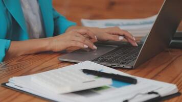 Asian Businesswoman Using laptop computer and working at office with calculator document on desk, doing planning analyzing the financial report, business plan investment, finance analysis concept. video