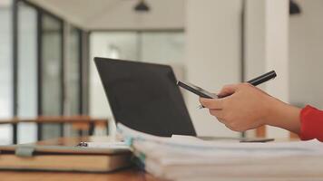 Asian Businesswoman Using laptop computer and working at office with calculator document on desk, doing planning analyzing the financial report, business plan investment, finance analysis concept. video