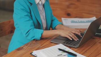 Asian Businesswoman Using laptop computer and working at office with calculator document on desk, doing planning analyzing the financial report, business plan investment, finance analysis concept. video