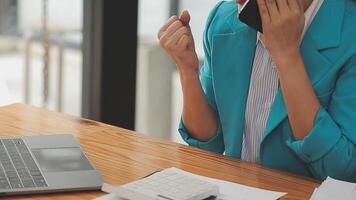 Asian Businesswoman Using laptop computer and working at office with calculator document on desk, doing planning analyzing the financial report, business plan investment, finance analysis concept. video