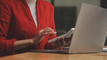 Asian Businesswoman Using laptop computer and working at office with calculator document on desk, doing planning analyzing the financial report, business plan investment, finance analysis concept. video