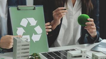 grupo de negocio personas planificación y que se discute en reciclar reducir reutilizar política símbolo en oficina reunión habitación. verde negocio empresa con Respetuoso del medio ambiente residuos administración regulación concepto.pionero video