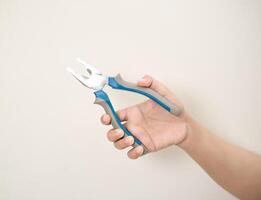 hand is holding a pliers on a white isolated background photo