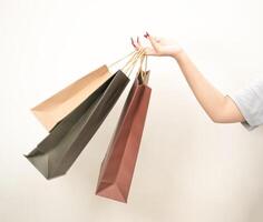 hand holding a shopping paper bag against a white isolated background photo